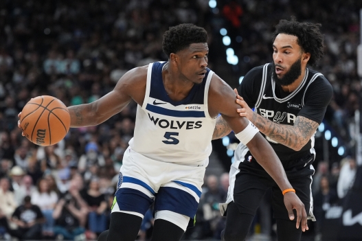 Minnesota Timberwolves guard Anthony Edwards (5) drives against San Antonio Spurs forward Julian Champagnie (30) during the second half of Game 5 of an NBA basketball second-round playoffs series in Minneapolis, Tuesday, May 12, 2026. (AP Photo/Eric Gay)