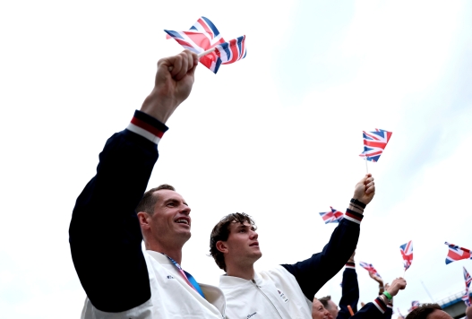 FILE - British tennis players Andy Murray, left, and Jack Draper wave flags from a boat on the Seine River during the opening ceremony for the 2024 Summer Olympics in Paris on July 26, 2024. (Naomi Baker/Pool Photo via AP)