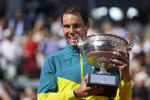Spain's Rafael Nadal bites the trophy after winning the final match against Norway's Casper Ruud in three sets, 6-3, 6-3, 6-0, at the French Open tennis tournament in Roland Garros stadium in Paris, France, Sunday, June 5, 2022. (AP Photo/Michel Euler)