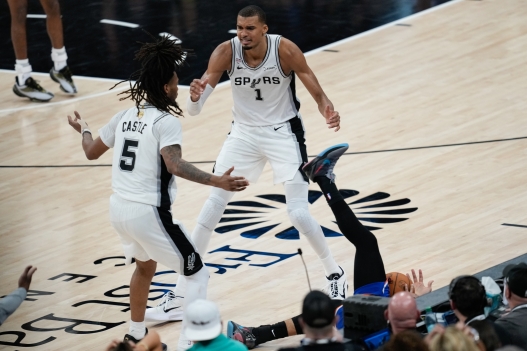 San Antonio Spurs forward Victor Wembanyama (1) and guard Stephon Castle (5) react as New York Knicks guard Jalen Brunson falls out of bounds during the second half of Game 2 of the NBA Finals basketball series, Friday, June 5, 2026, in San Antonio. (AP Photo/David J. Phillip)