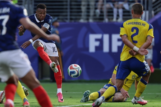 France's Kylian Mbappe (10) scores their first goal past Sweden's Gustaf Lagerbielke (2) during the World Cup round of 32 soccer match between France and Sweden in East Rutherford, N.J., near New York, Tuesday, June 30, 2026. (AP Photo/Adam Hunger)
