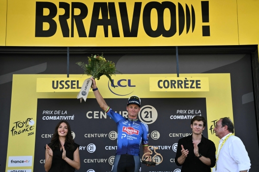 Former French President Francois Hollande (R) looks on as Alpecin - Premier Tech team's Dutch rider Mathieu van der Poel receives the most combative rider's award on the podium after the 9th stage of the 113th edition of the Tour de France cycling race, 154,6 km between Malemort and Ussel in central France, on July 12, 2026. (Photo by Jeff PACHOUD / AFP)