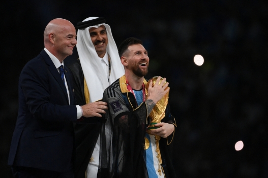Argentina's forward #10 Lionel Messi holds the World Cup trophy after receiving it from FIFA President Gianni Infantino and Qatar's Emir Sheikh Tamim bin Hamad al-Thani during the Qatar 2022 World Cup trophy ceremony after the football final match between Argentina and France at Lusail Stadium in Lusail, north of Doha on December 18, 2022. Argentina won in the penalty shoot-out. (Photo by FRANCK FIFE / AFP)