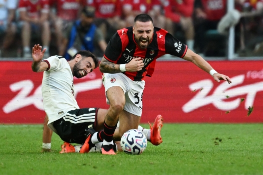 Manchester United's Portuguese midfielder #08 Bruno Fernandes (L) and AC Milan's Spanish defender Mario Gila (R) vie for the ball during the pre-season friendly football match between Manchester United and AC Milan at the Tarczynski Arena in Wroclaw, Poland, on August 15, 2026. (Photo by Sergei GAPON / AFP)