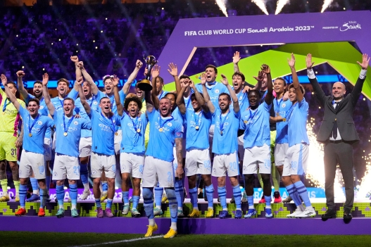 FILE - Manchester City's Kyle Walker, center, lifts the trophy as players and coach Pep Guardiola, right, celebrate at the end of the Soccer Club World Cup final match between Manchester City FC and Fluminense FC at King Abdullah Sports City Stadium in Jeddah, Saudi Arabia, Friday, Dec. 22, 2023. Manchester City won 4-0. (AP Photo/Manu Fernandez, File)