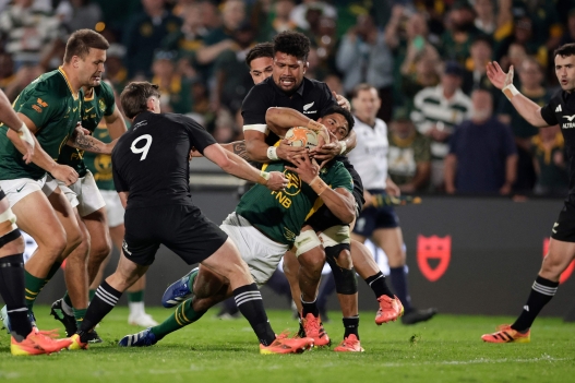 New Zealand's number eight Ardie Savea tackles South Africa's fly-half Sacha Feinberg-Mngomezulu during the Rugby's Greatest Rivalry international rugby union match between South Africa and New Zealand at Ellis Park Stadium in Johannesburg, on August 22, 2026. (Photo by PHILL MAGAKOE / AFP)