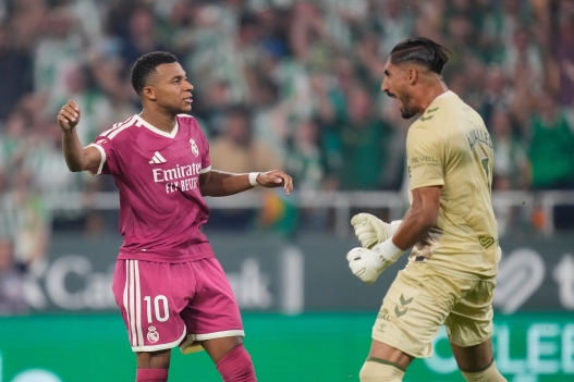 Real Madrid's Kylian Mbappe, left, reacts after failing a chance to score from the penalty spot in front of Betis' goalkeeper Alvaro Valles during the Spanish La Liga soccer match between Real Betis and Real Madrid in Seville, Spain, Friday, Sept. 4, 2026. (AP Photo/Jose Breton)