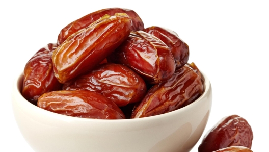 Bowl of dried dates isolated on white background