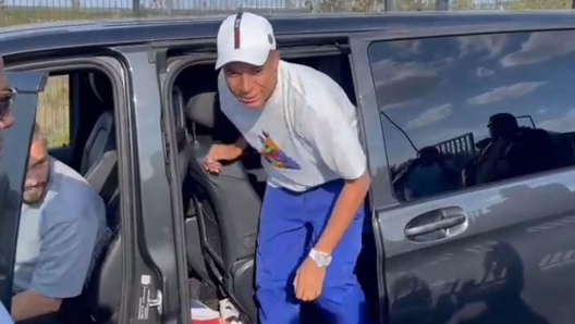 A video image grab shows Paris Saint-Germain's forward Kylian Mbappe as he stops at the entrance of the Paris Saint-Germain training grounds to meet with fans and sign autographs, on the sidelines of a training session in Poissy, western suburbs of Paris, on July 22, 2023. Kylian Mbappe signed autographs and took selfies with club supporters after a training session with PSG reserve players on July 22, less than 24 hours after the club left him out of their squad for a pre-season tour of Japan and South Korea. PSG gave no reason for the omission of France's captain but 24-year-old Mbappe has said for weeks that he is refusing to sign a new contract. (Photo by Tom MASSON / AFP)