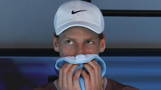 Italy's Jannik Sinner wipes his sweat during a break against Serbia's Novak Djokovic in their men's singles semi-final match on day 13 of the Australian Open tennis tournament in Melbourne on January 26, 2024. (Photo by David GRAY / AFP) / -- IMAGE RESTRICTED TO EDITORIAL USE - STRICTLY NO COMMERCIAL USE --