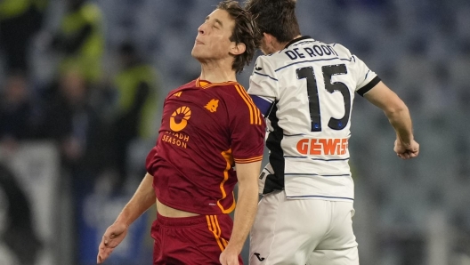 Roma's Edoardo Bove, left, and Atalanta's Marten de Roon, center, vie for the ball during the Serie A soccer match between Roma and Atalanta, at Rome's Olympic Stadium, Sunday, Jan. 7, 2024. (AP Photo/Andrew Medichini)