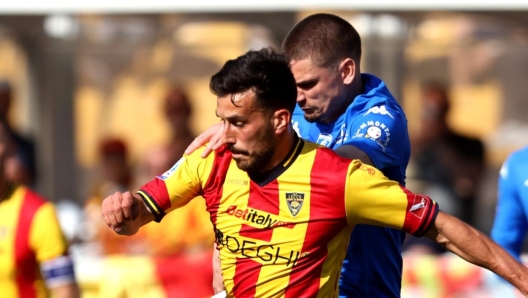 LECCE, ITALY - APRIL 13: Nicola Sansone of Lecce competes for the ball with Razvan Marin of Empoli during the Serie A TIM match between US Lecce and Empoli FC at Stadio Via del Mare on April 13, 2024 in Lecce, Italy. (Photo by Maurizio Lagana/Getty Images)