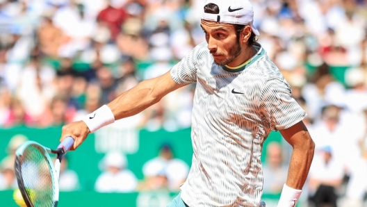 Italy's Lorenzo Musetti plays a backhand return to Serbia's Novak Djokovic during their Monte Carlo ATP Masters Series Tournament round of 16 tennis match on the Rainier III court at the Monte Carlo Country Club on April 11, 2024. (Photo by Valery HACHE / AFP)