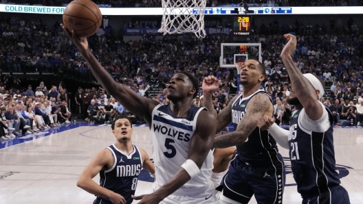 Minnesota Timberwolves guard Anthony Edwards (5) scores against the Dallas Mavericks during the second half in Game 4 of the NBA basketball Western Conference finals, Tuesday, May 28, 2024, in Dallas. (AP Photo/Julio Cortez)