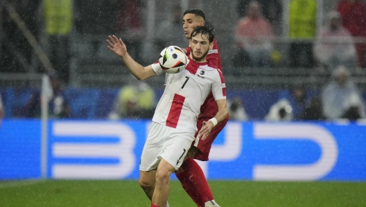 Georgia's Khvicha Kvaratskhelia, foreground, challenges for the ball with Turkey's Mert Muldur during a Group F match between Turkey and Georgia at the Euro 2024 soccer tournament in Dortmund, Germany, Tuesday, June 18, 2024. (AP Photo/Alessandra Tarantino)