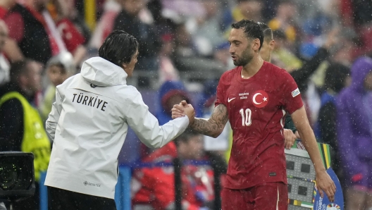 Turkey's Hakan Calhanoglu, right, shakes hand with his coach Vincenzo Montello during a Group F match between Turkey and Georgia at the Euro 2024 soccer tournament in Dortmund, Germany, Tuesday, June 18, 2024. (AP Photo/Alessandra Tarantino)