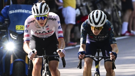 Slovenia's Tadej Pogacar, left, and Denmark's Jonas Vingegaard break away from the pack during the second stage of the Tour de France cycling race over 199.2 kilometers (123.8 miles) with start in Cesenatico and finish in Bologna, Italy, Sunday, June 30, 2024. (Bernard Papon/Pool Photo via AP)