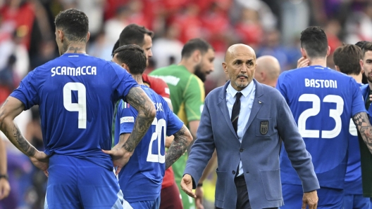 Italy's coach Luciano Spalletti, center, walks between his players after a round of sixteen match between Switzerland and Italy at the Euro 2024 soccer tournament in Berlin, Germany, Saturday, June 29, 2024. (Robert Michael/dpa via AP)