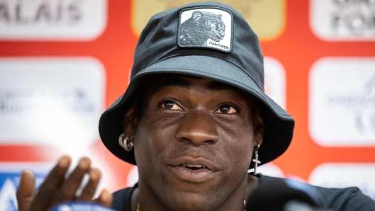 Italy's football striker Mario Balotelli gestures at a press conference on September 1, 2022, after he signed a two-year contract with Swiss side FC Sion, the 11th club of his career. - Sion will become Balotelli's fifth club since January 2019, when he attempted to relaunch his career with Marseille after two successful seasons at Nice. (Photo by Fabrice COFFRINI / AFP)