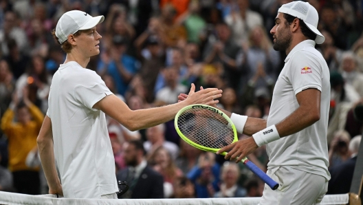 Italy's Matteo Berrettini (R) congratulates Italy's Jannik Sinner on winning their men's singles second round tennis match on the third day of the 2024 Wimbledon Championships at The All England Lawn Tennis and Croquet Club in Wimbledon, southwest London, on July 3, 2024. Sinner won the Match 7-6, 7-6, 2-6, 7-4. (Photo by ANDREJ ISAKOVIC / AFP) / RESTRICTED TO EDITORIAL USE