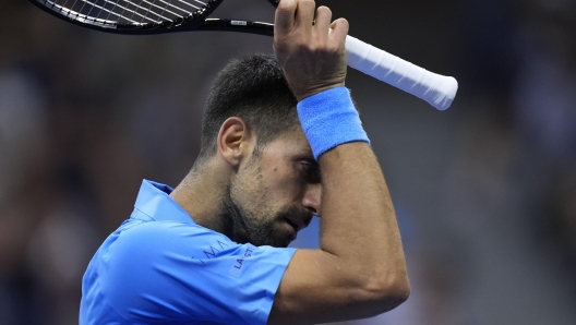 Novak Djokovic, of Serbia, wipes his face against Alexei Popyrin, of Australia, during a third round match of the U.S. Open tennis championships, Friday, Aug. 30, 2024, in New York. (AP Photo/Julia Nikhinson)