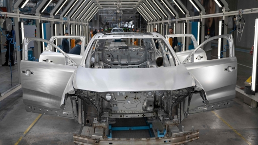 This photograph taken in Bursa on May 17, 2024 shows employees working on a car assembly line at a factory of Togg at the Gemlik Togg Technology Campus. Thousands of vehicles are rolling off its campus on the Sea of Marmara, built in less than two years. Already renowned for its car manufacturing, Turkey is showing its teeth in the electric car market with its champion, Togg. (Photo by Yasin AKGUL / AFP)