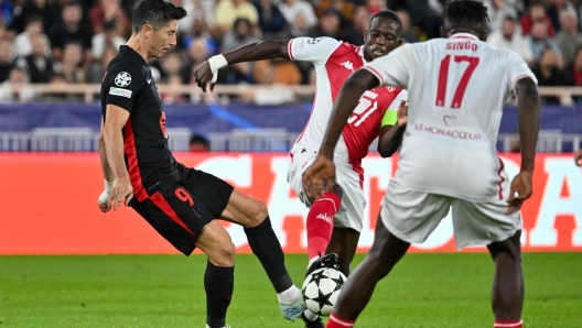 Barcelona's Polish forward #09 Robert Lewandowski (L) fights for the ball with Monaco's Ivorian defender #17 Wilfried Singo during the UEFA Champions League 1st round day 1 football match between AS Monaco and FC Barcelona at the Louis II Stadium in the Principality of Monaco on September 19, 2024. (Photo by Miguel MEDINA / AFP)