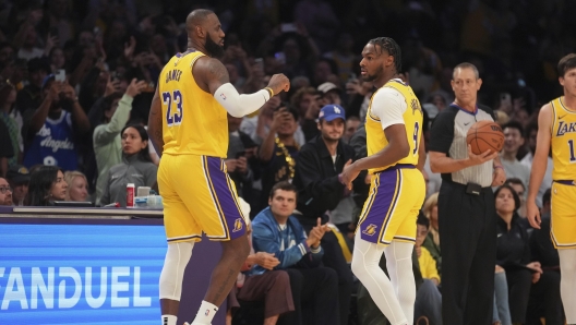 Los Angeles Lakers forward LeBron James (23) and guard Bronny James (9) stand on the court during the first half of an NBA basketball game against the Minnesota Timberwolves, Tuesday, Oct. 22, 2024, in Los Angeles. (AP Photo/Eric Thayer)