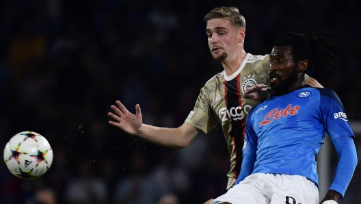 Napoli's Cameroonian midfielder Andre-Frank Zambo Anguissa (R) fights for the ball with Ajax's Dutch midfielder Kenneth Taylor during the UEFA Champions League Group A football match between SSC Napoli and Ajax Amsterdam at the Diego Armando Maradona Stadium in Naples on October 12, 2022. (Photo by Filippo MONTEFORTE / AFP)