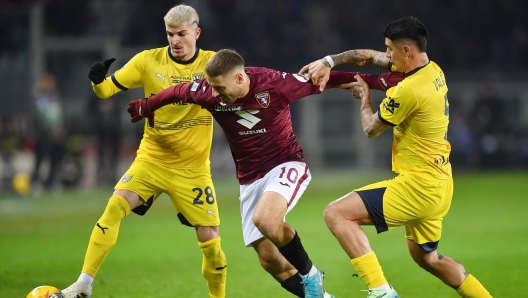 TURIN, ITALY - JANUARY 05: Nikola Vlasic of Torino runs with the ball whilst under pressure from Valentin Mihaila and Simon Sohm of Parma Calcio during the Serie A match between Torino and Parma at Stadio Olimpico di Torino on January 05, 2025 in Turin, Italy. (Photo by Valerio Pennicino/Getty Images)