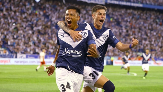 TOPSHOT - Velez Sarsfield's defender #34 Damian Fernandez celebrates after scoring with defender #31 Valentin Gomez during the Argentine Professional Football League Tournament 2024 'Cesar Luis Menotti' football match between Velez Sarsfield and Huracan at the Jose Amalfitani stadium in Buenos Aires on December 15, 2024. (Photo by ALEJANDRO PAGNI / AFP)