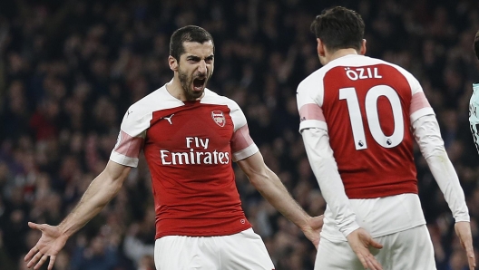 Arsenal's Armenian midfielder Henrikh Mkhitaryan (L) celebrates scoring his team's second goal with Arsenal's German midfielder Mesut Ozil during the English Premier League football match between Arsenal and Bournemouth at the Emirates Stadium in London on February 27, 2019. (Photo by Ian KINGTON / AFP) / RESTRICTED TO EDITORIAL USE. No use with unauthorized audio, video, data, fixture lists, club/league logos or 'live' services. Online in-match use limited to 120 images. An additional 40 images may be used in extra time. No video emulation. Social media in-match use limited to 120 images. An additional 40 images may be used in extra time. No use in betting publications, games or single club/league/player publications. /