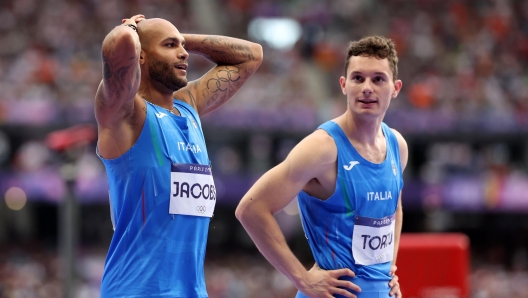 PARIS, FRANCE - AUGUST 09: Lamont Marcell Jacobs (L) and Filippo Tortu of Team Italy react after competing in the Men's 4x100m Relay Final on day fourteen of the Olympic Games Paris 2024 at Stade de France on August 09, 2024 in Paris, France. (Photo by Hannah Peters/Getty Images)