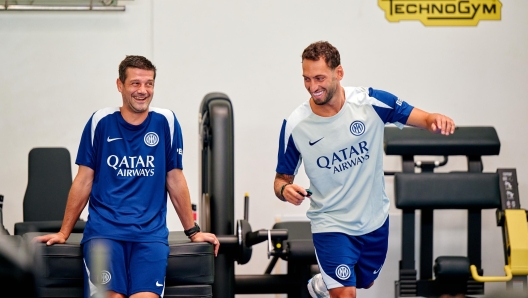 COMO, ITALY - JULY 24: Head Coach Cristian Chivu of FC Internazionale speaks with Hakan Calhanoglu of FC Internazionale during the FC Internazionale training session at the club`s training ground BPER Training Centre at Appiano Gentile on July 24, 2025 in Como, Italy. (Photo by Mattia Ozbot - Inter/Inter via Getty Images)