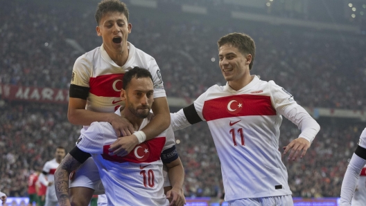 epa12528201 Hakan Calhanoglu of Turkey celebrates with teammates Arda Guler (up) and Kenan Yildiz (R) after scoring the 1-0 goal during the FIFA World Cup 26 UEFA qualifier between Turkey and Bulgaria in Bursa, Turkey, 15 November 2025.  EPA/TOLGA BOZOGLU