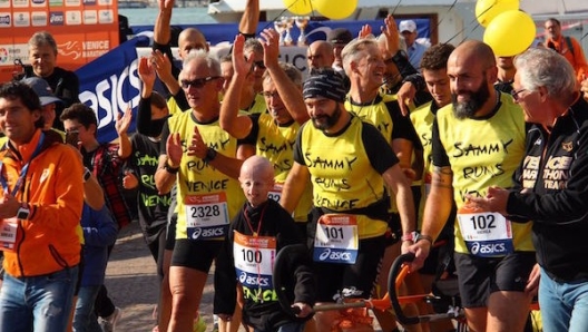 Sammy, fondatore dell’associazione italiana Progeria, all'arrivo della Venice Marathon tira la Joelette.