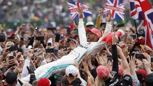 Il surf di Hamilton sul pubblico di Silverstone, ormai una tradizione. Epa