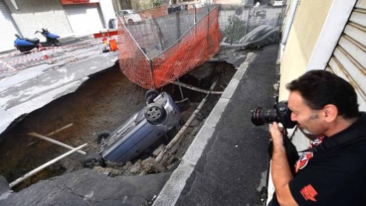 Un’auto caduta in una voragine a Genova lo scorso agosto. Ansa