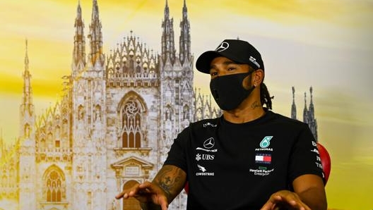 Lewis Hamilton, 35 anni, in total black davanti all’immagine del duomo di Milano. AFP