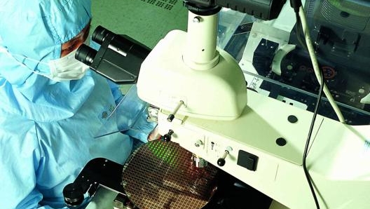 Un tecnico Tsmc al lavoro su un wafer di silicio stampato