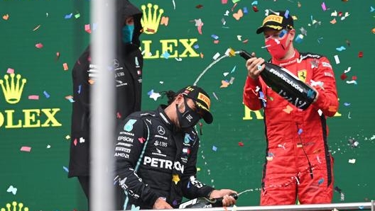 Sebastian Vettel (a destra) festeggia con Hamilton sul podio. Epa