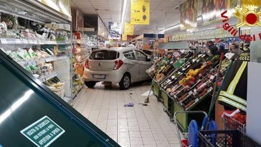 L'auto che ha sfondato la porta antipanico del supermarket, in primo piano, per un errore di manovra del guidatore