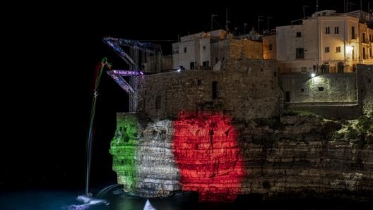 La scogliera di Polignano illuminata con il tricolore in occasione della tappa del Red Bull Cliff Diving del 2 giugno 2019