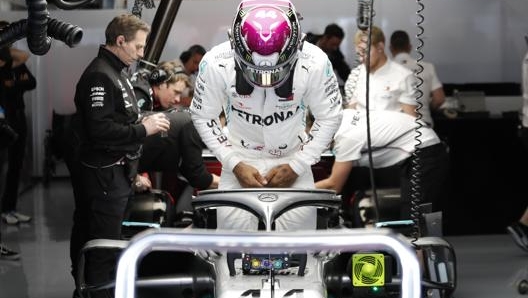 Lewis Hamilton si cala nell’abitacolo della sua Mercedes. Lapresse