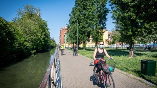 Ciclisti lungo il naviglio della Martesana a Milano. Ansa