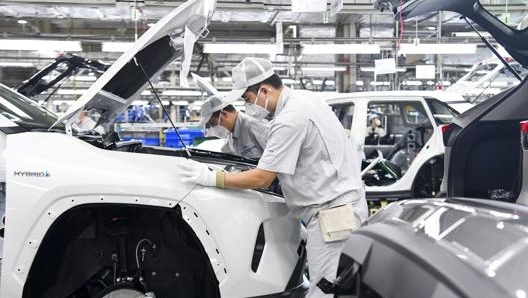 Operai al lavoro su un Suv Toyota nell'impianto produttivo FAW-Toyota di Changchun