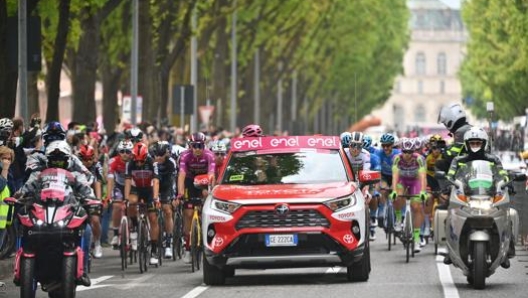 Il via della tappa: a sinistra la moto dei regolatori, al centro l'auto della direzione corsa, a destra la moto ripresa. LaPresse