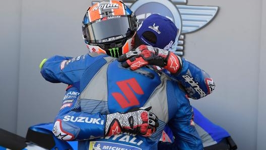 L’abbraccio dei piloti Suzuki nei paddock. Afp