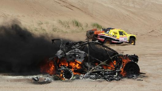 Una vettura a fuoco nel corso di una Dakar. Epa