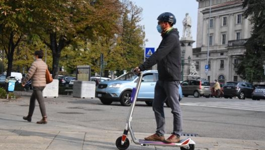 In monopattino con il casco lungo le strade di Bergamo. Ansa